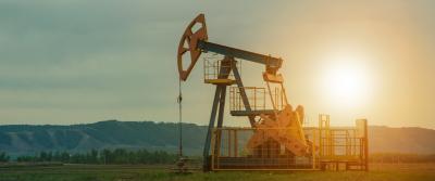 Oilfield with sun in background.