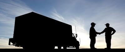 silhouette photo of two people shaking hands next to truck