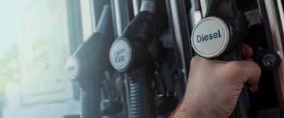 person at gas pump holding diesel fuel nozzle