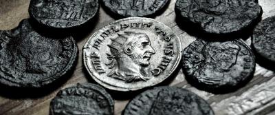 multiple old coins laying on table