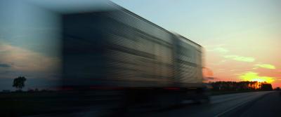 truck driving down highway with sunset