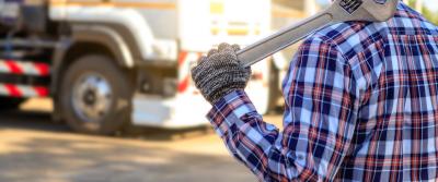 Man in plaid shirt holding wrench