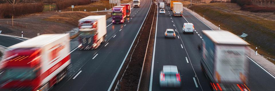 Trucks driving on divided highway bg