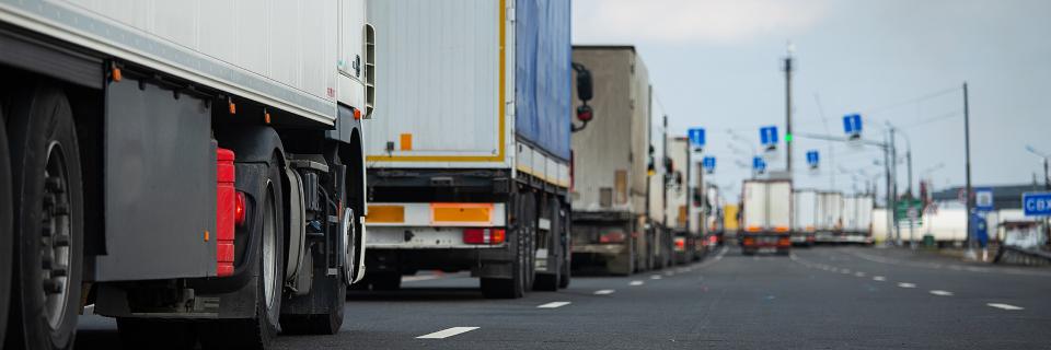 line of trucks on highway bg