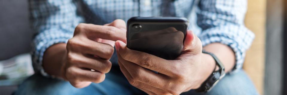 person scrolling through phone while sitting