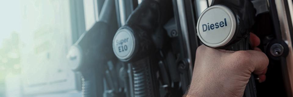 person at gas pump holding diesel fuel nozzle