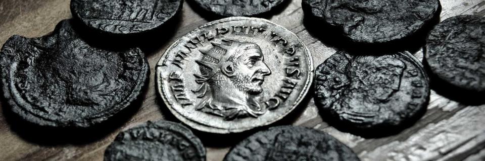 multiple old coins laying on table