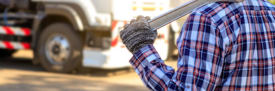 Man in plaid shirt holding wrench
